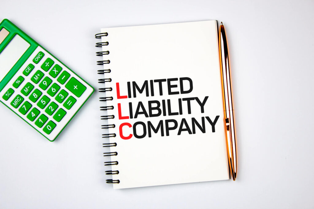 Image of a calculator next to a notebook that says Limited Liability Company 
